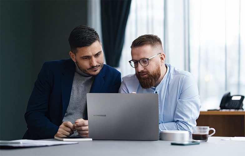 Egy kis &uuml;zleti irod&aacute;ban az alkalmazottak dolgoznak vagy egym&aacute;ssal besz&eacute;lgetnek.